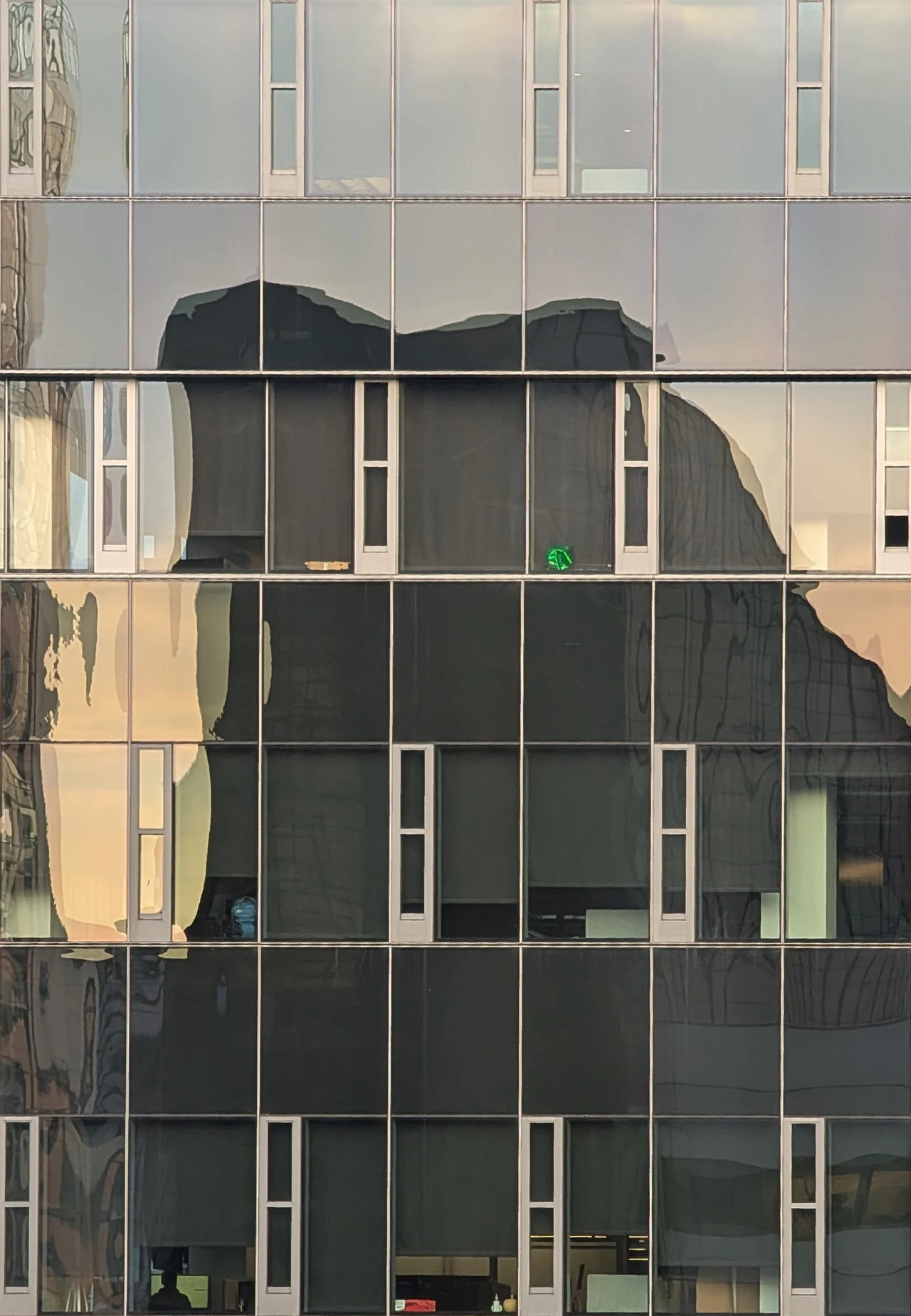 An amber reflection falling across a quiet window grid.