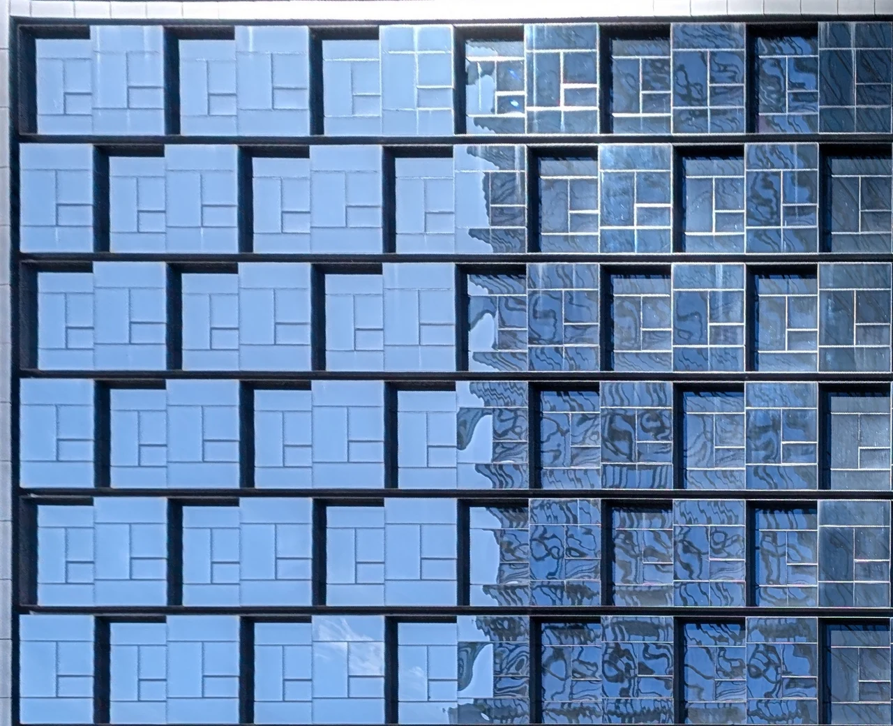 Blue rectangular window panels forming a repeated geometric pattern.