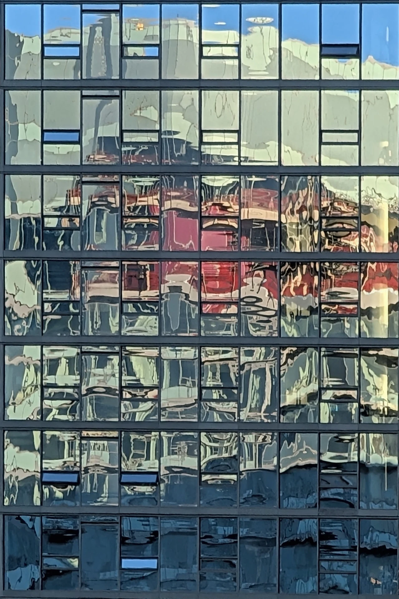 Green, blue, and warm reflections broken into a grid of glass.